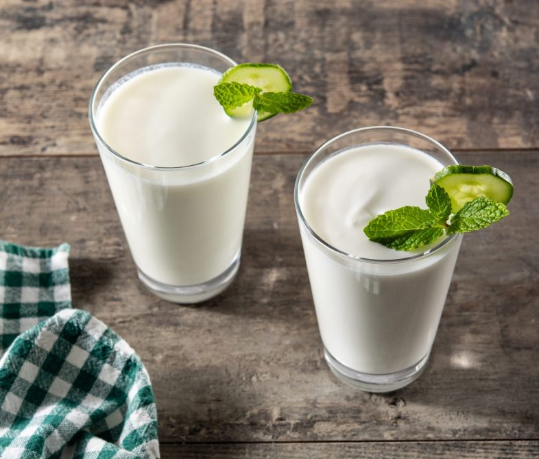 Ayran drink with mint and cucumber in glass on wooden table
